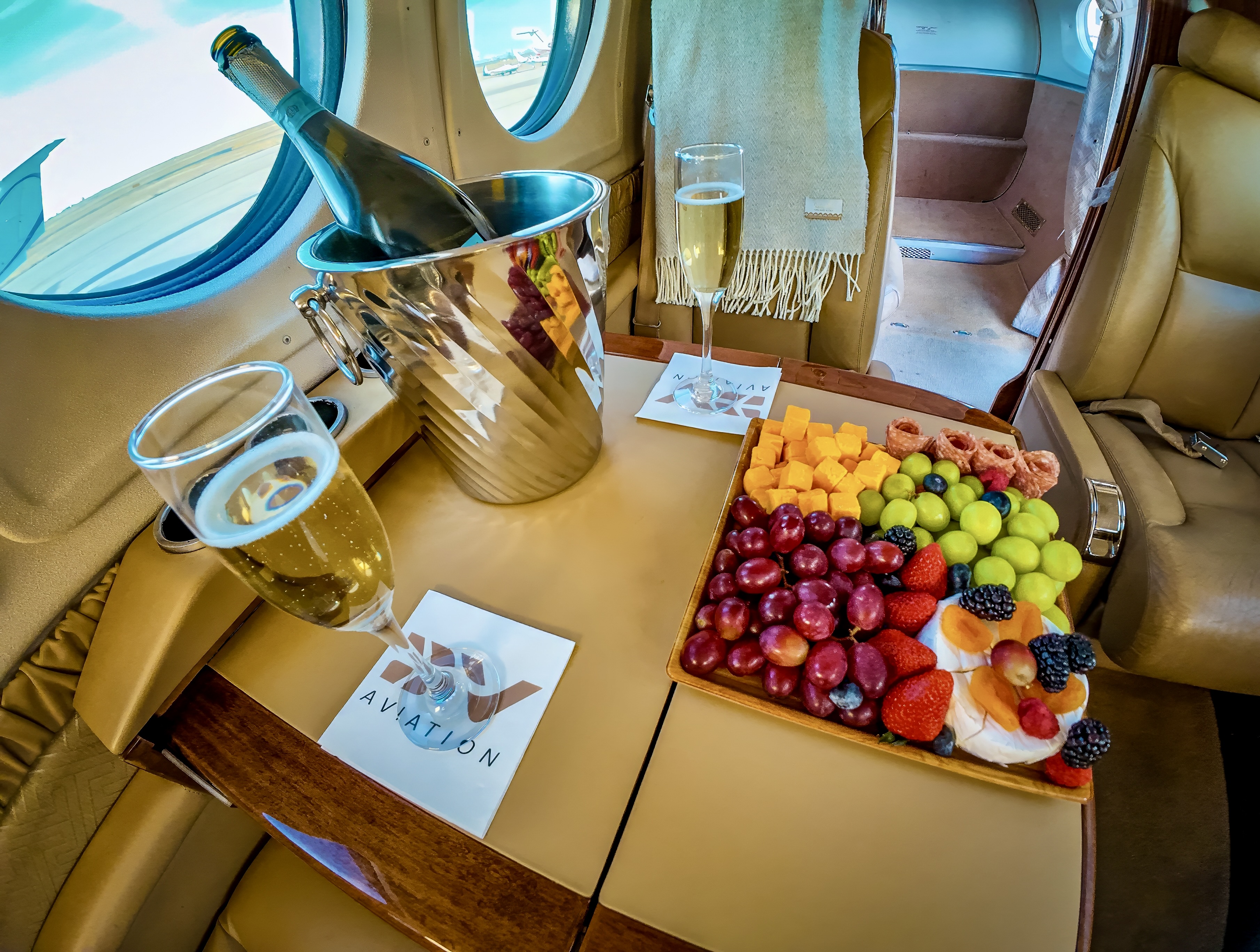 DV Aviation cabin interior — champagne and fresh fruit aboard a private charter